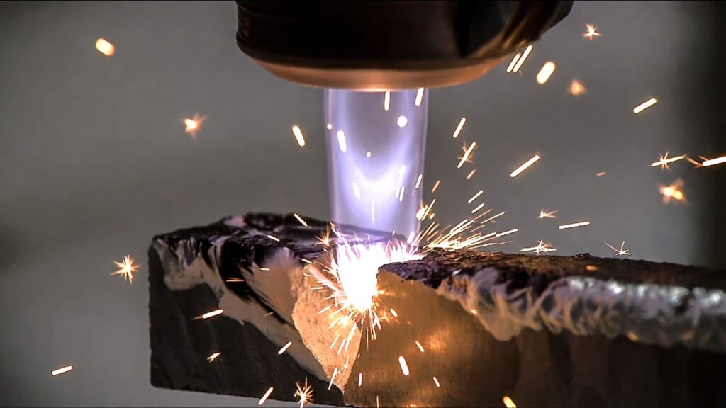 Industrial laser cutting with sparks and focused beam on metal