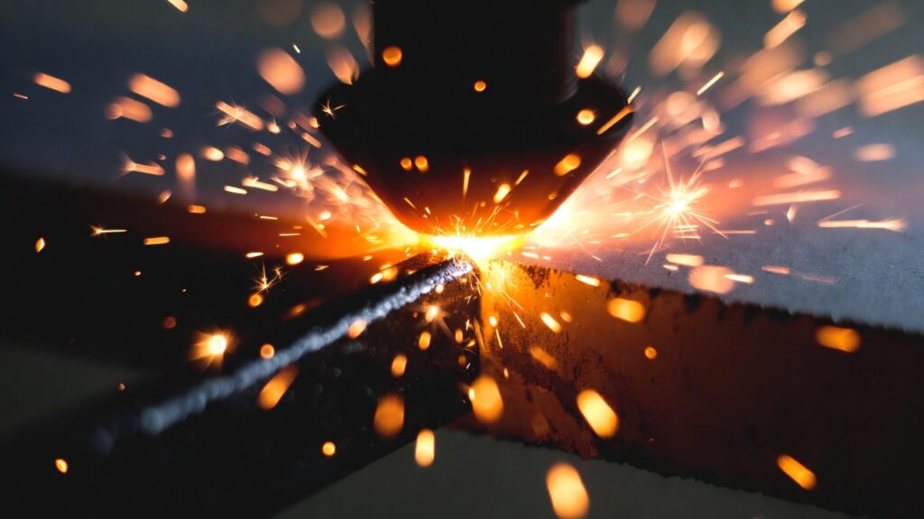 Dramatic close-up of laser-cut edge with sparks and clean cut line